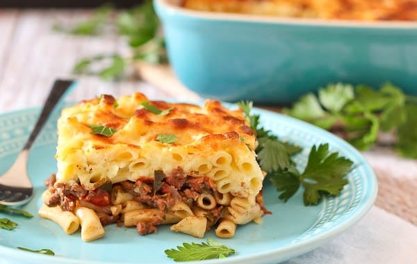 Front view closeup of plated pastitsio garnished with parsley leaves.