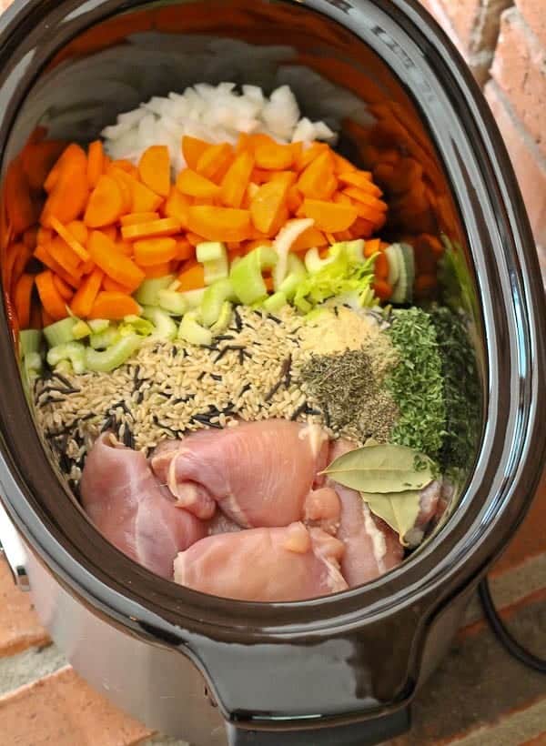 Overhead of crockpot containing all the ingredients of the soup before it's cooked, except for the broth.