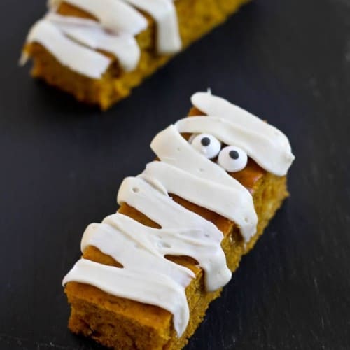 Don't throw a Halloween party without these fun pumpkin bar edible mummies. They use a lessened amount of sugar and are low in fat so you can maybe even eat two mummies! Get the easy recipe on RachelCooks.com!