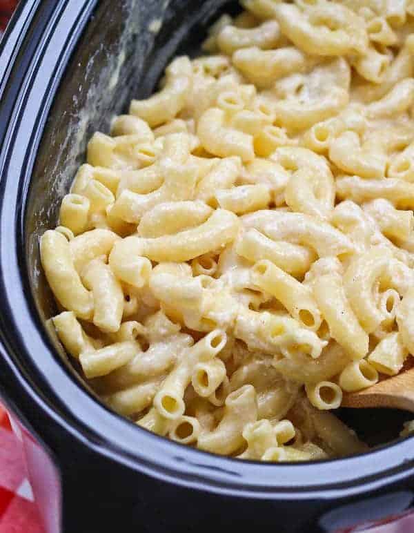 Thick macaroni in a white cheese sauce in a black slow cooker.