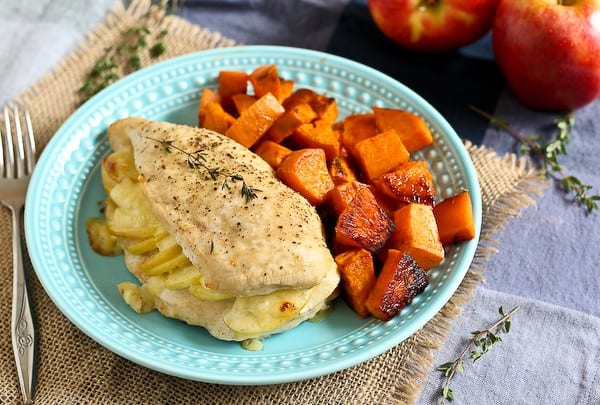 Plated dinner with chicken and sweet potatoes on decorative blue plate.