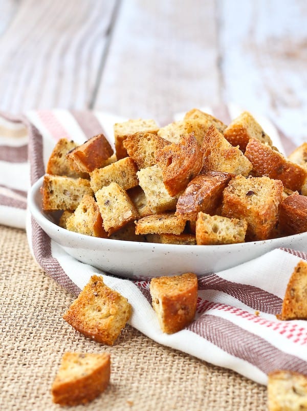 Homemade croutons piled up in a small white bowl.