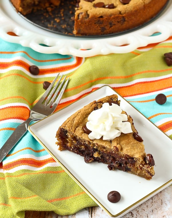 Slice of deep dish cookie with whipped cream on top.