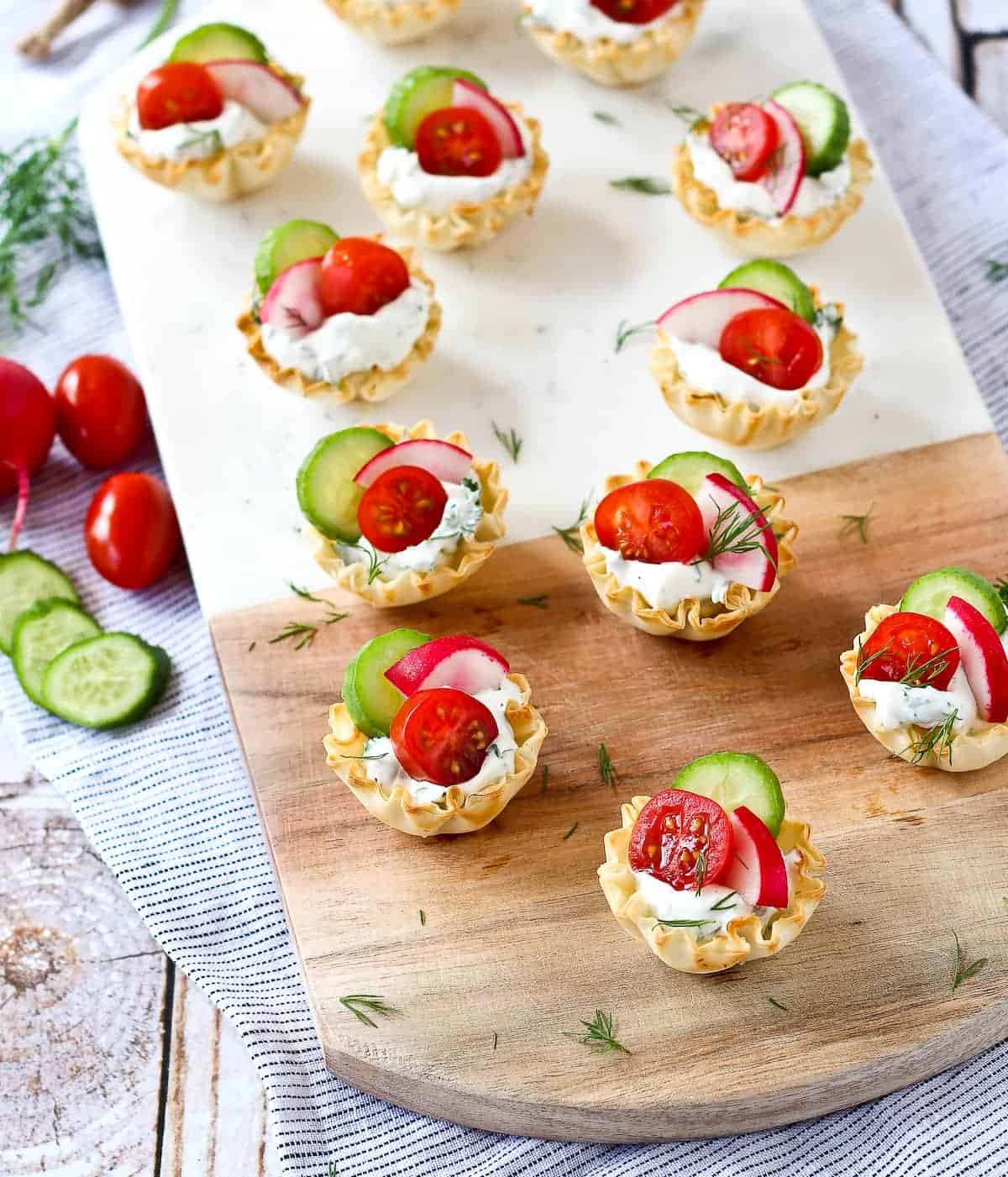 Spring appetizer cups with tomato, radish, and cucumber.