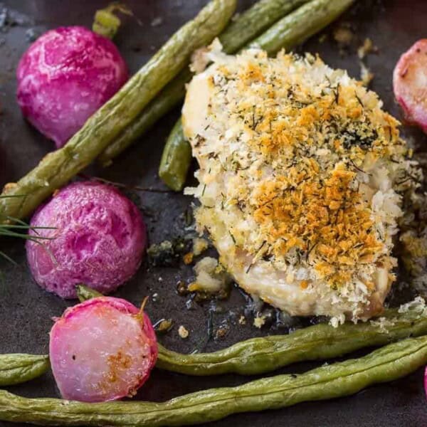 Overhead of roasted chicken and vegetables on sheet pan.