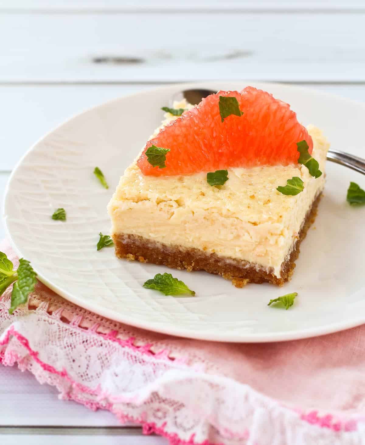 Grapefruit cheesecake square, topped with a slice of grapefruit.
