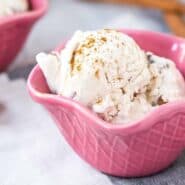 Two scoops of no churn cinnamon ice cream in a pink bowl.