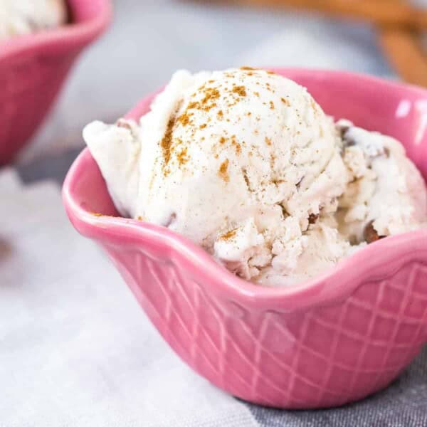 Two scoops of no churn cinnamon ice cream in a pink bowl.