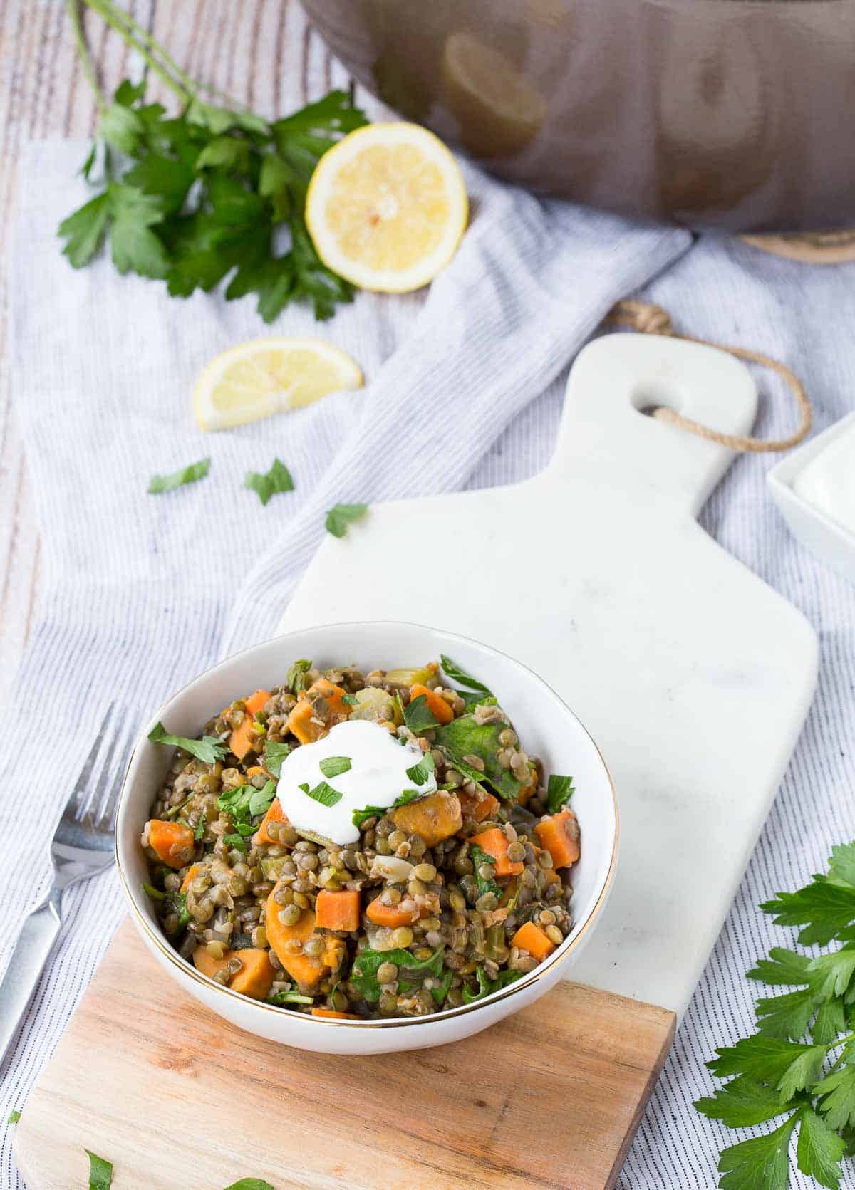 Overhead of lentils in serving bowl, garnished with fresh cilantro and a dollop of Greek yogurt.