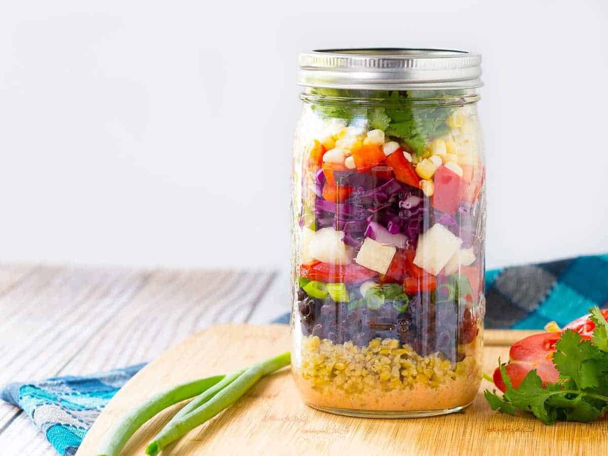 Colorful chopped salad in a mason jar.