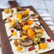 Experience a taste of fall with this ricotta flatbread! The party starts in the spiced ricotta and carries throughout the fun autumn toppings: bacon, squash, apples, mushrooms, and maple candied pepitas. You'll want to eat this all year! Get the easy recipe on RachelCooks.com!