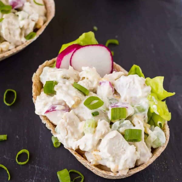 Closeup of salad in tortilla boat on black background.