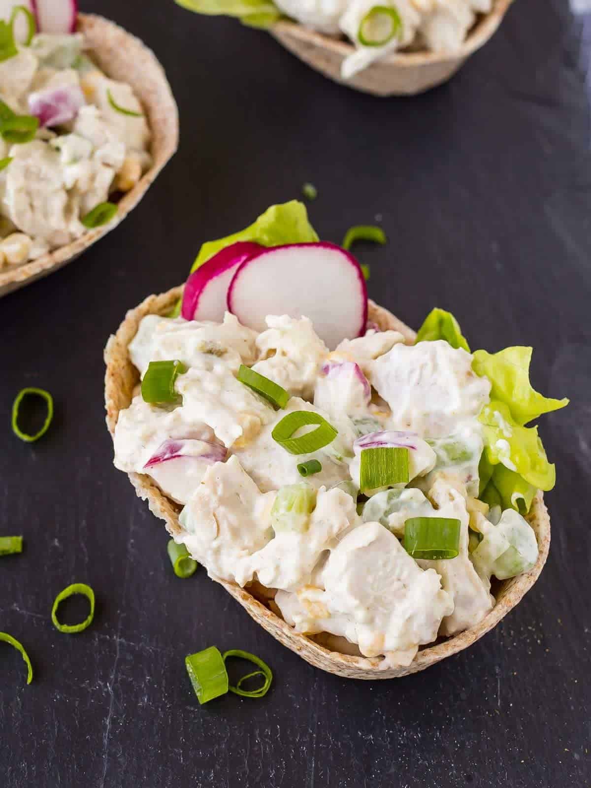 Closeup of salad in tortilla boat, on black background.