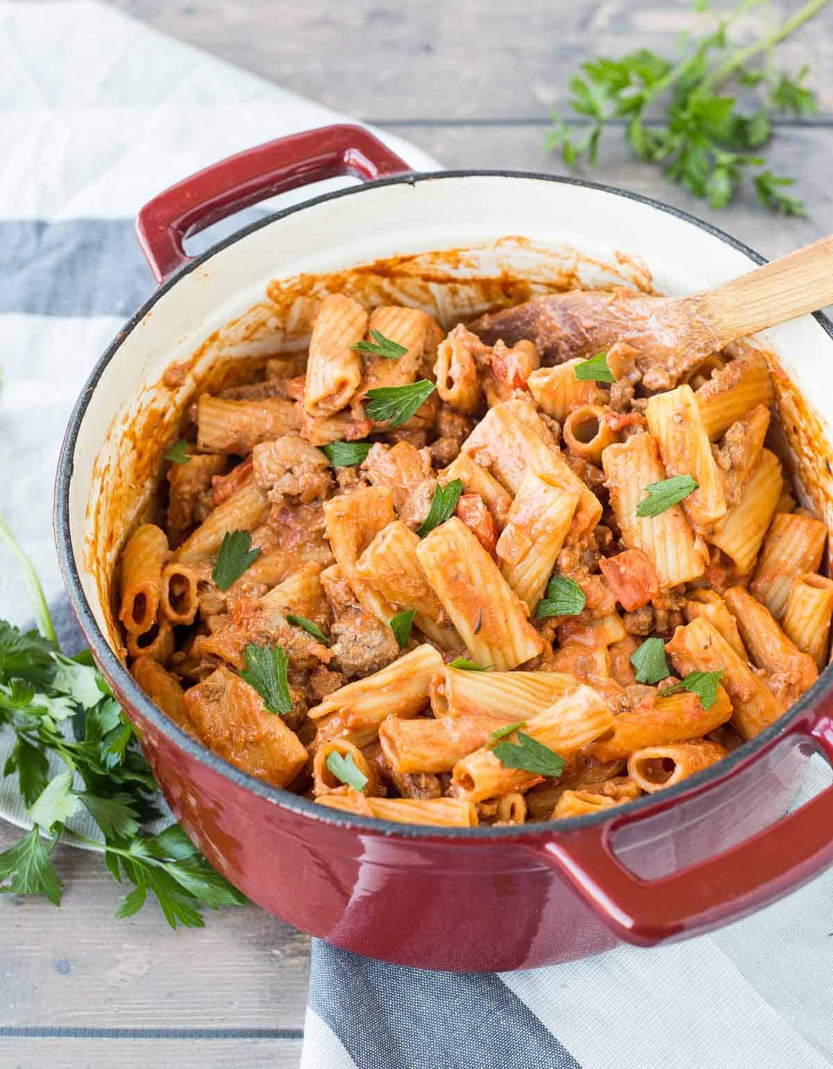 Overhead of Dutch oven containing fully cooked rigatoni pasta dish.