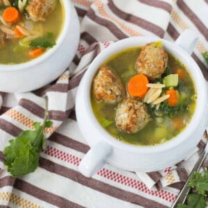 Overhead of meatball soup served in white bowls.