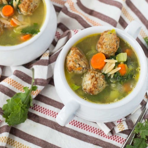 Overhead of meatball soup served in white bowls.