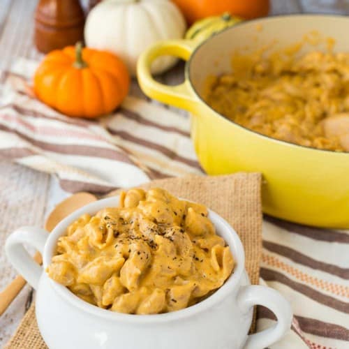 close view of pumpkin macaroni and cheese beer in white bowl and a yellow crockpot in the background