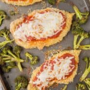 Overhead of chicken Parmesan with broccoli on sheet pan.