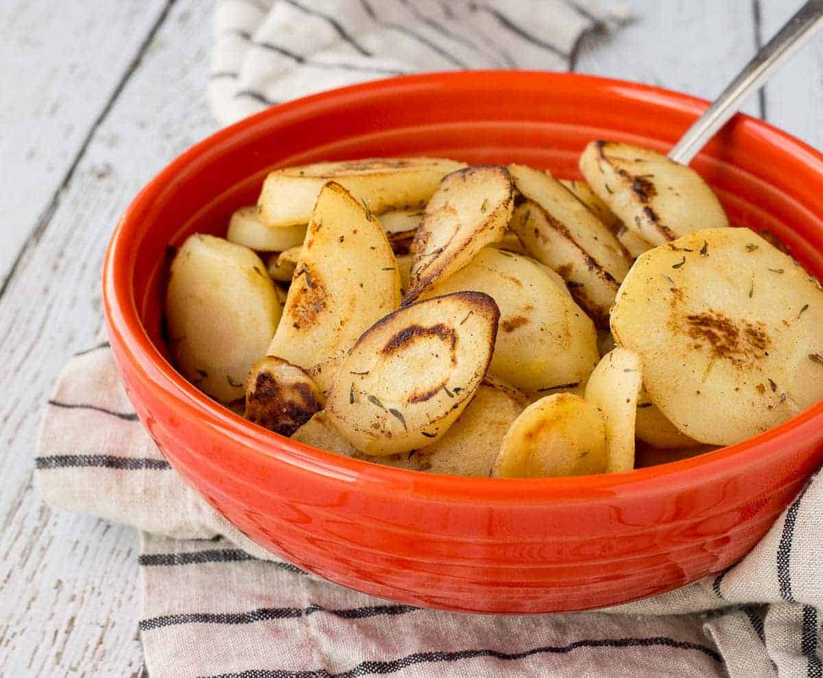 Orange serving dish with parsnips.