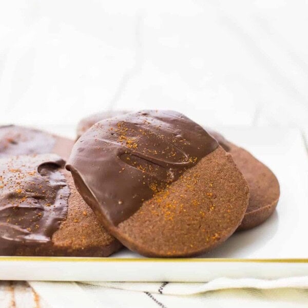 Close up front view of several cookies on white plate.