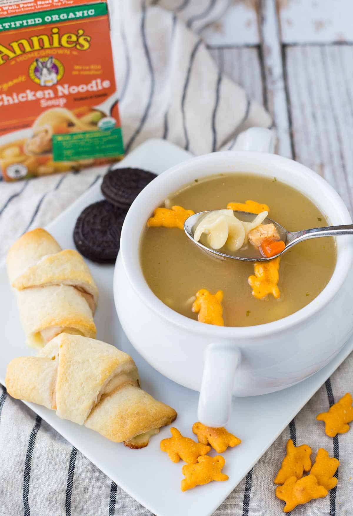 Soup garnished with bunny crackers, with spoon inserted.