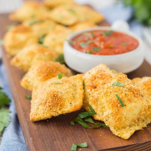 Baked not fried, these toasted cheese ravioli are the perfect game day snack or appetizer. You won't be able to stop snacking on them! Get the recipe on RachelCooks.com!