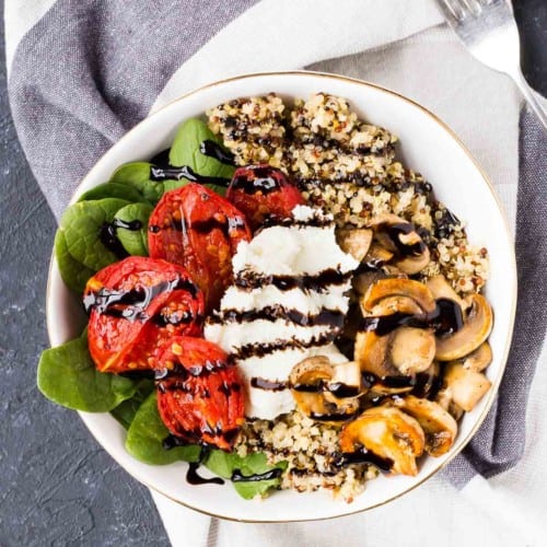 Overhead of shallow white bowl containing arranged salad with balsamic reduction drizzle.