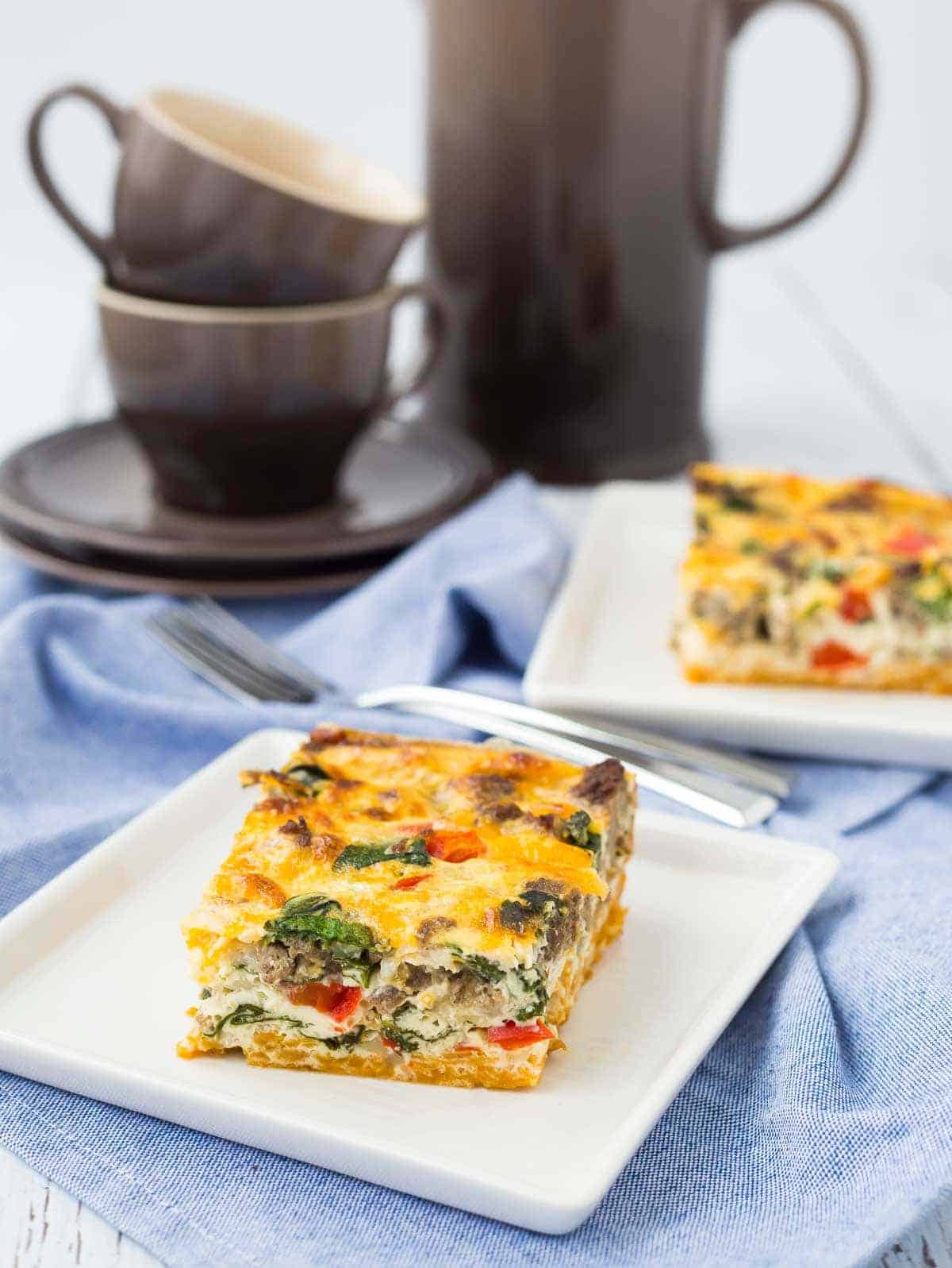 Servings of egg white casserole with mugs and carafe in background.