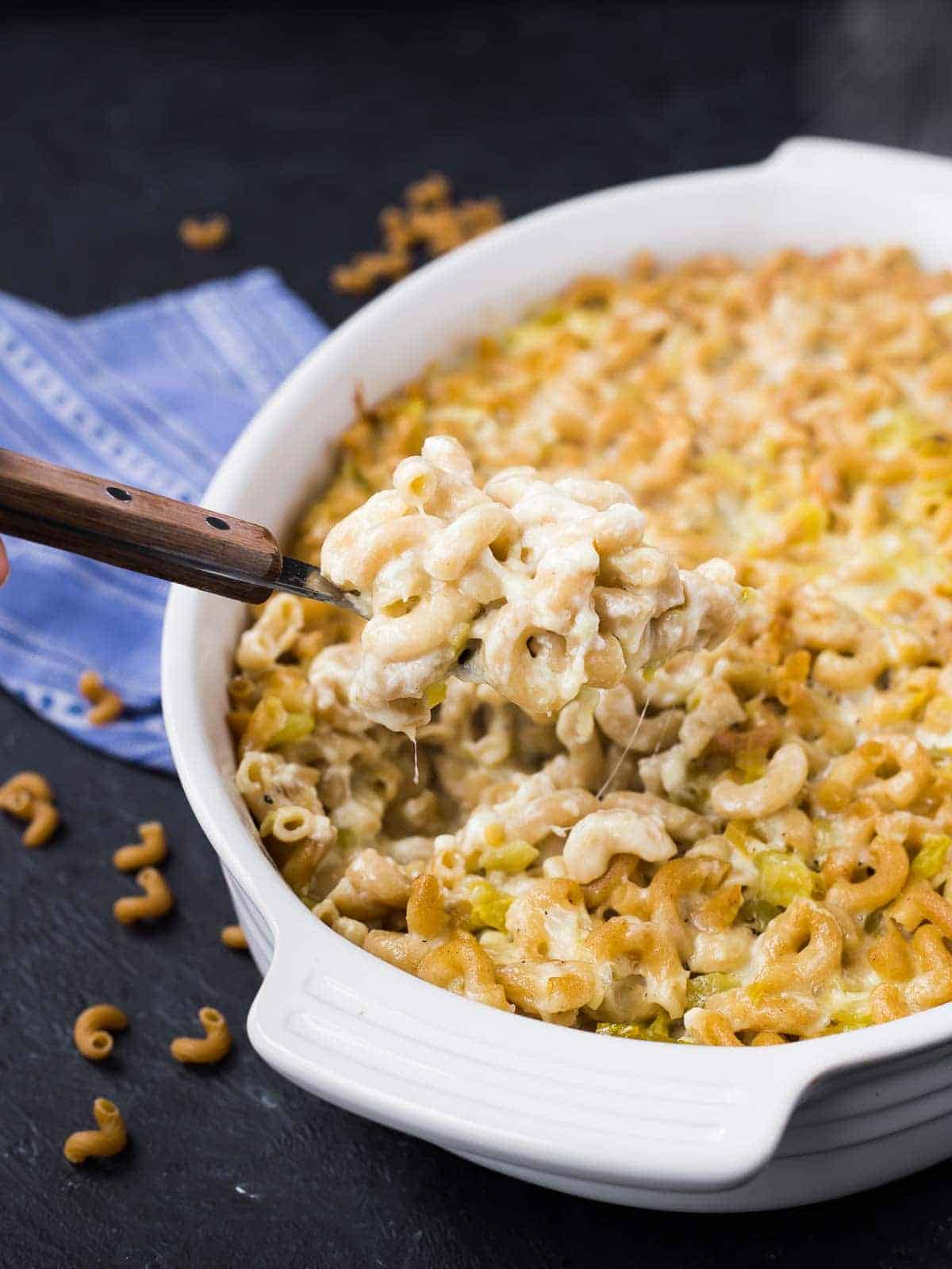 Green chile mac and cheese in a white casserole dish.