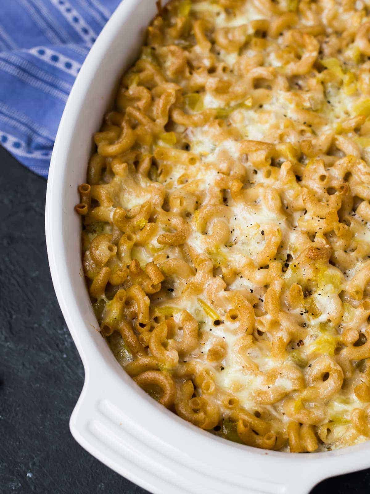 Green chile mac and cheese in a white casserole dish.