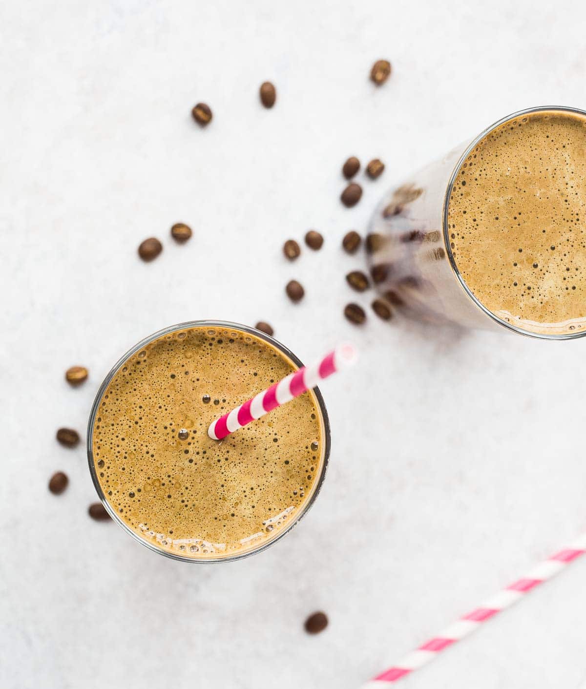 Overhead view of mocha protein shake, surrounded by scattered coffee beans.