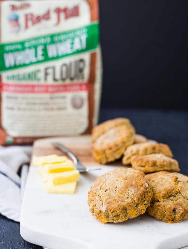 Front view of biscuits, with bag of Bob's Red Mill whole wheat flour in background.