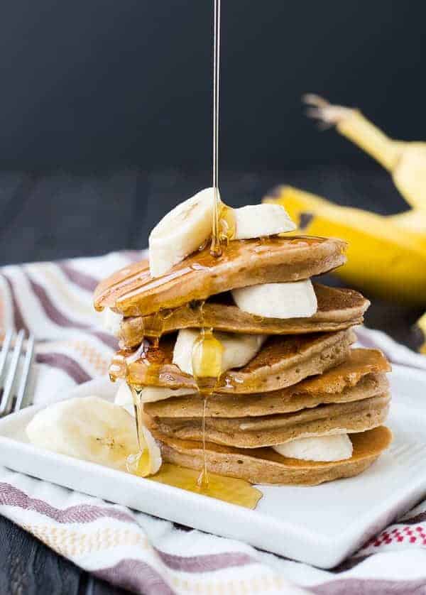Stack of banana pancakes drizzled with maple syrup.