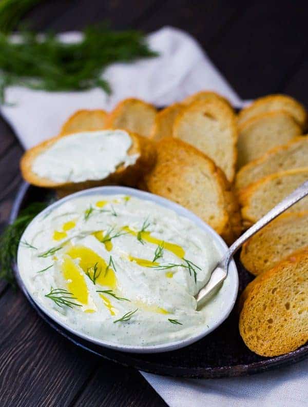 Whipped feta with lemon and dill is the perfect summer spread! Classy and sophisticated with the bright flavors of lemon, it's perfect spread on a crisp slice of French bread! Get the easy recipe on RachelCooks.com!