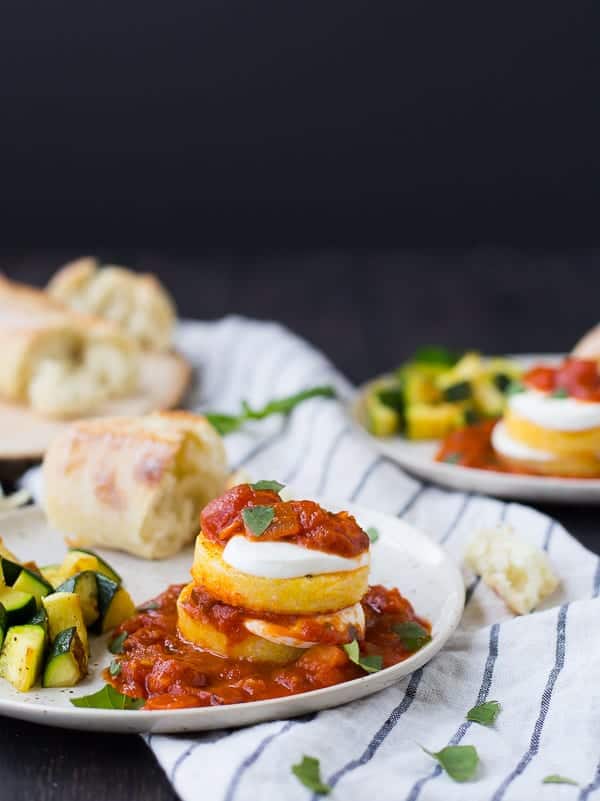 Polenta slices stacked with cheese and marinara sauce.