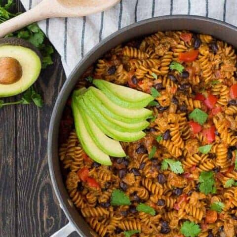 In a rush? This 30 minute One Pot Taco Pasta with Ground Turkey and Black Beans is here to save the day! It's creamy, satisfying, and the pasta cooks in the same pan as everything else! Get the healthy 30 minute recipe on RachelCooks.com!