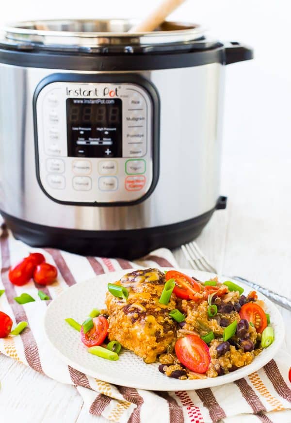 Round white plate with chicken and quinoa, with Instant pot in background.