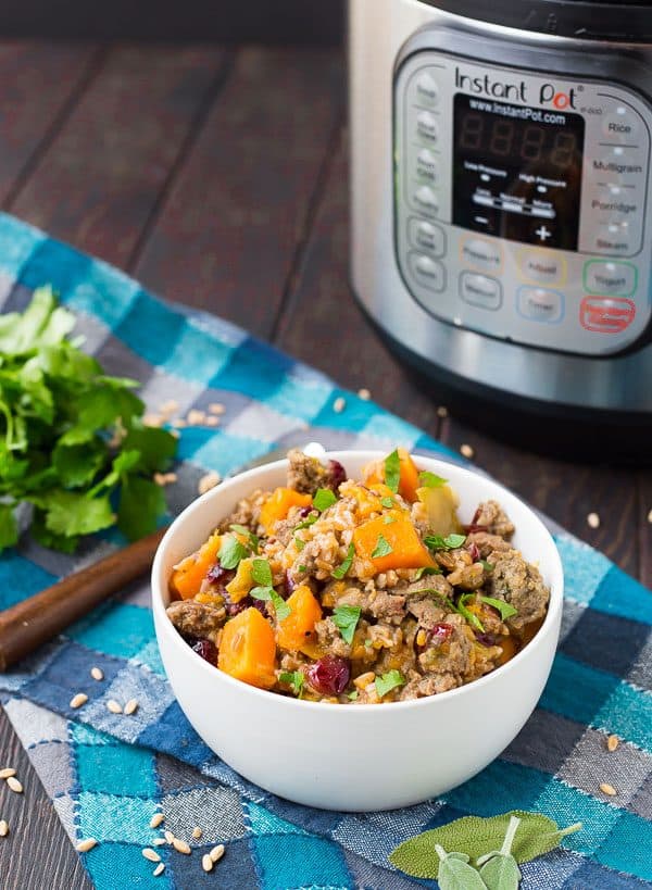 Round white bowl with farro stuffing garnished with fresh herbs.