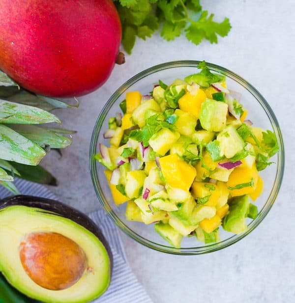 Mango Avocado Salsa is the perfect topping to any taco or salad, and it's irresistible piled up on a chip! You'll love the creamy avocado, sweet mango, and tart pineapple in every bite! Get the fun recipe on RachelCooks.com!