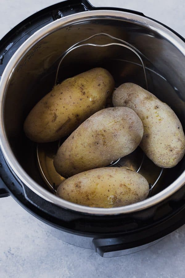 Overhead of four potatoes on rack inside of Instant Pot.