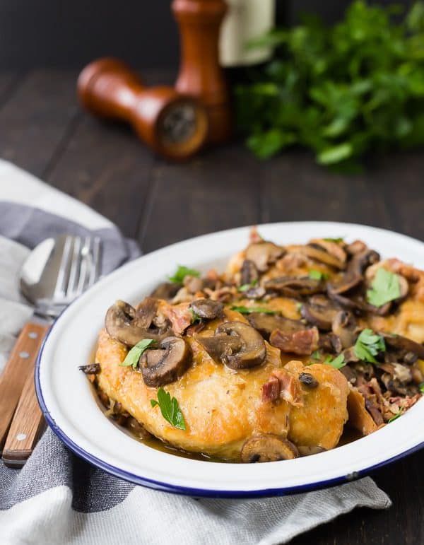 Chicken marsala in serving dish with fork and spoon alongside.