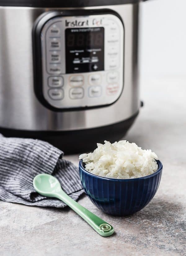 Serving of rice in bowl, with Instant pot in background.