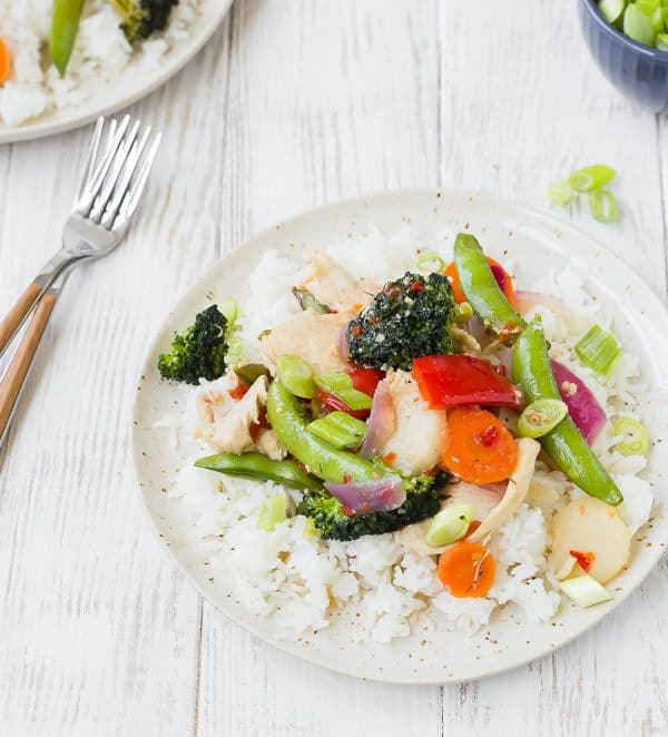 Overhead of stir fry with white rice on white plate, with fork.