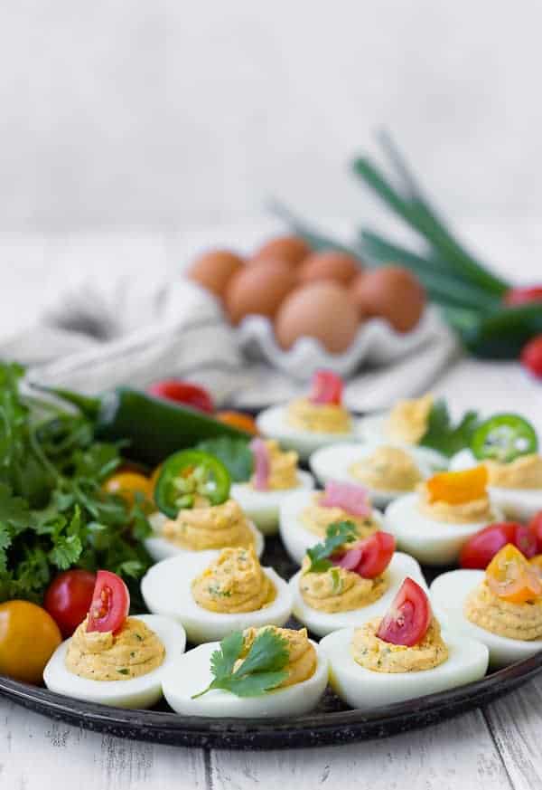 Front view of eggs on platter with several items in background.