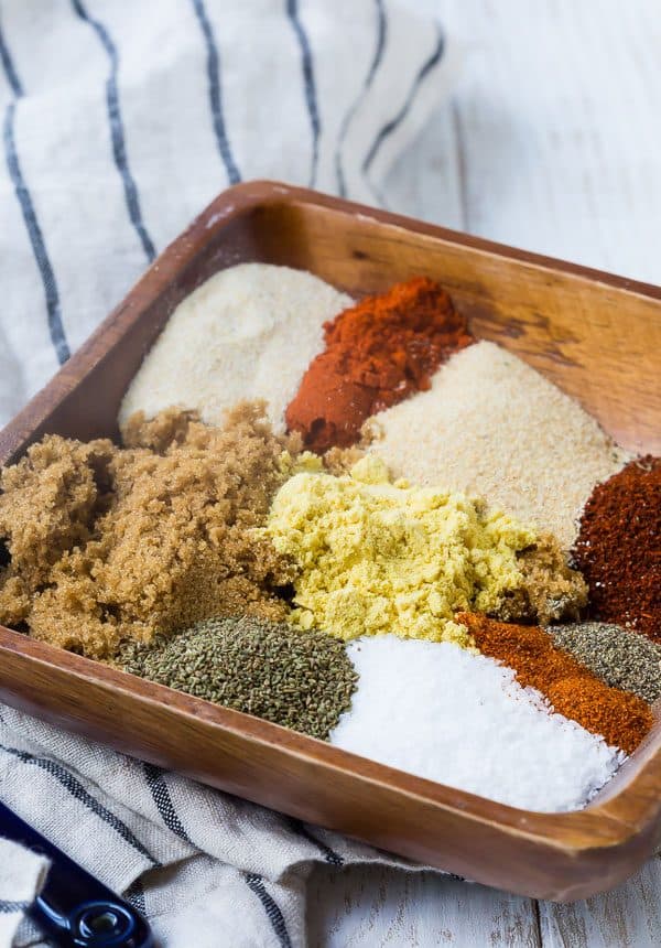 Closeup of rub ingredients in wooden dish, not blended together.