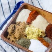 Ingredients of bbq rub in small wooden dish.