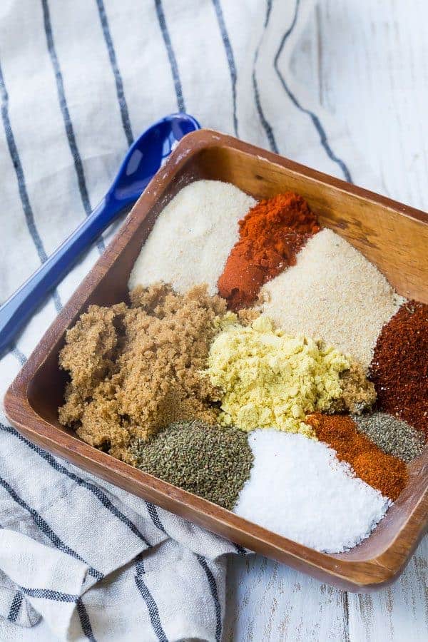 Ingredients in small wooden dish, unblended, with blue ceramic spoon.