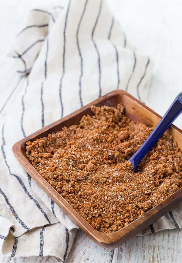 This BBQ rub is the perfect sweet and savory rub for pork and chicken. It's easy to make with ingredients you probably already have in your pantry. Don't grill without it! Get the recipe on RachelCooks.com! image of bbq rub in a wooden bowl with a blue spoon