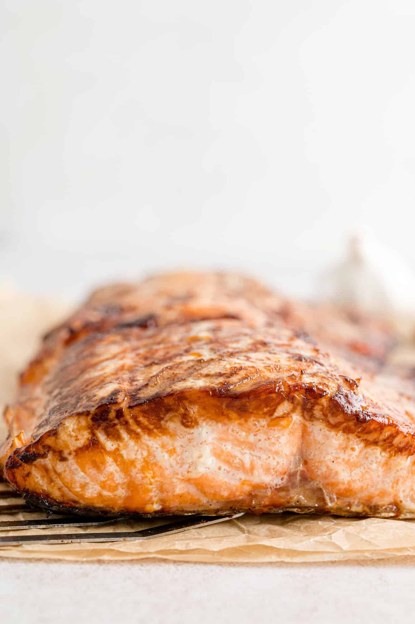 Side view of a grilled salmon fillet on parchment paper.