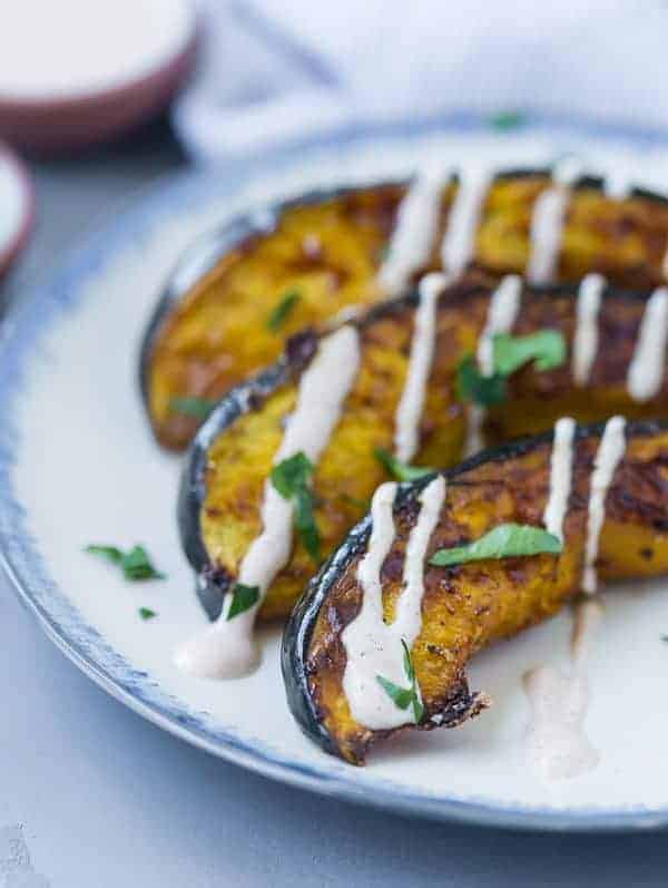 Close up view of roasted squash with a white yogurt drizzle.